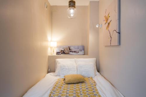 Habitación pequeña con cama con almohada. en Appartement Lyon Gerland - Enjoy in Lyon, en Lyon