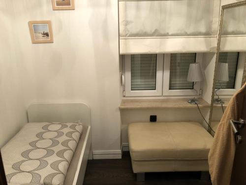 een kleine slaapkamer met een bed en een raam bij Apartment Amorino in Opatija