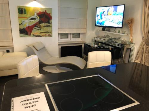 een woonkamer met een tv en een tafel en stoelen bij Apartment Amorino in Opatija
