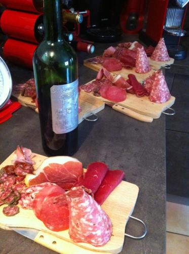 a bottle of wine and some cuts of meat on cutting boards at Junior Suite Le Pied de Mulet in Brouchaud