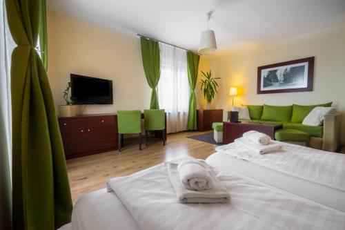 a hotel room with two beds and a couch at Penzión Talisman in Rajecké Teplice