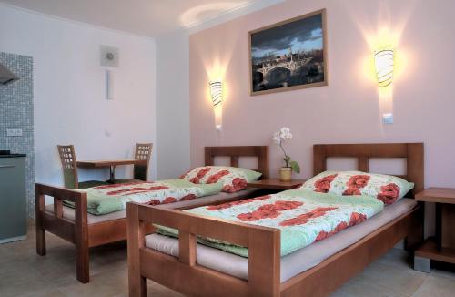- une chambre avec 2 lits, une table et des lumières dans l'établissement Penzion U Vinotéky, à Nymburk