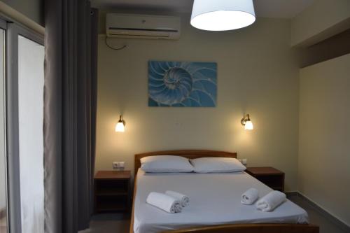 1 dormitorio con 1 cama y 2 toallas en Zotos Apartment, en Himare