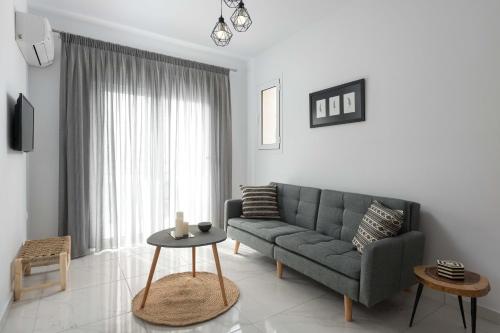 a living room with a couch and a table at L & C Boutique Apartments in Kremasti