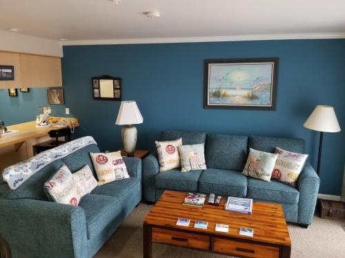 a living room with two blue couches and a table at The Landing at Newport Condominium Hotel in Newport