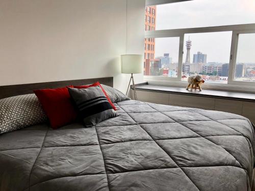 Un dormitorio con una cama con un perro mirando por la ventana en Boutique Apartment Downtown 1106, en Ciudad de México