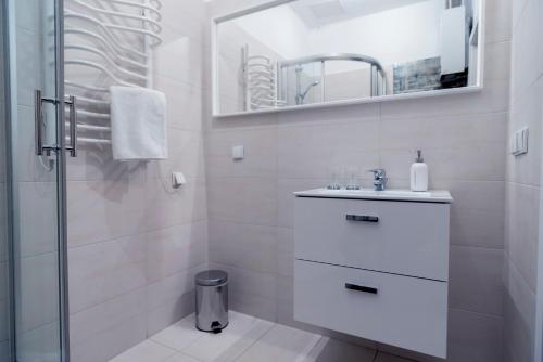 a white bathroom with a sink and a shower at "Apartament na Kazimierzu" in Krakow