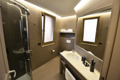 a bathroom with two sinks and a mirror at Petit Hotel Elita in Shkodër