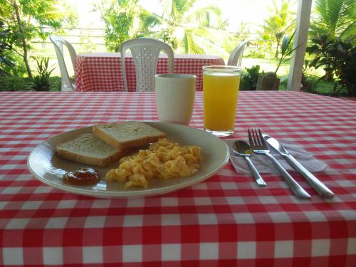 a plate of food on a red and white checkered table with drinks at Hotel Nuquimar in Nuquí