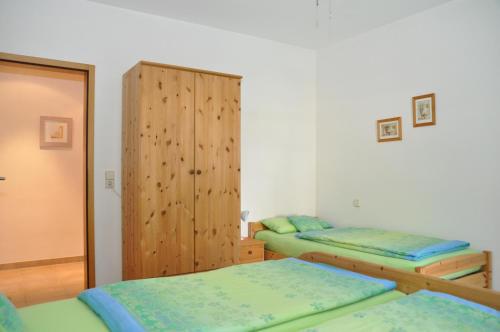 a bedroom with two beds and a wooden cabinet at Villa Delfin in Sutivan