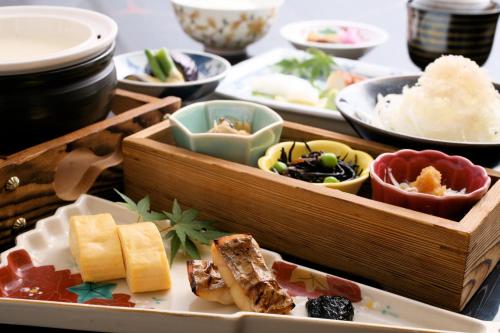 a table topped with trays of different types of food at Hotel New Awaji in Sumoto