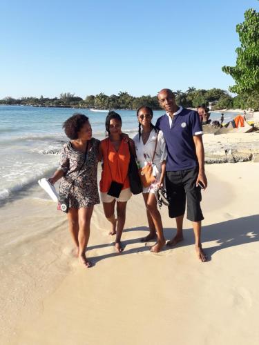 a group of people walking on the beach at Paradise Place Grande King in Cave Hill