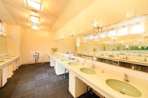 a large bathroom with three sinks and mirrors at Ueno Station Hostel Oriental Ⅱ(Men Only) in Tokyo