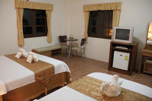 a hotel room with two beds and a television at Groovy Bungalows in Ao Nang Beach