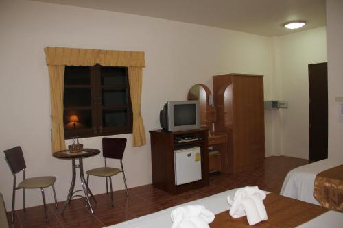 a hotel room with a bed and a television at Groovy Bungalows in Ao Nang Beach