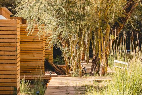 a wooden fence with trees in a garden at Lodge Quelana in San Pedro de Atacama