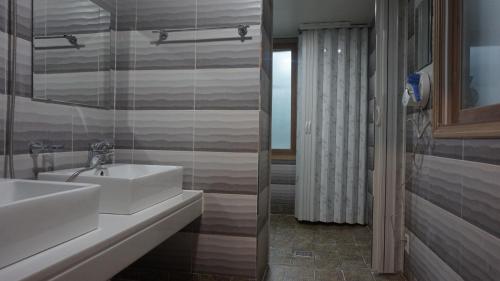 a bathroom with a white sink and a mirror at Sh Guesthouse in Chuncheon