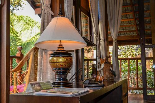 a lamp on top of a table in a room at Rice Barn And Rooms in Hang Dong