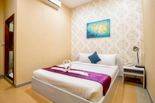a bedroom with a bed with a towel on it at White Residence Hotel & Apartment in Phnom Penh