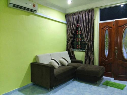 - un salon avec un canapé et une fenêtre dans l'établissement Homestay Izzahrah Arau UNIFI, Fully Aircond, à Arau