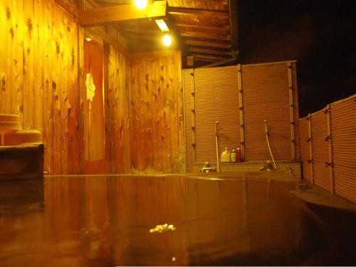 Łazienka z drewnianymi ścianami i drewnianą podłogą w obiekcie Gero Onsen Fugaku w mieście Gero