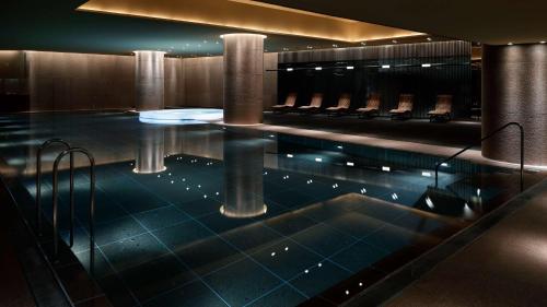 a swimming pool in a building with chairs at Grand Hyatt Tokyo in Tokyo