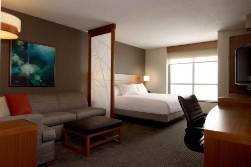 a hotel room with a bed and a couch at Hyatt Place Charlotte Downtown in Charlotte