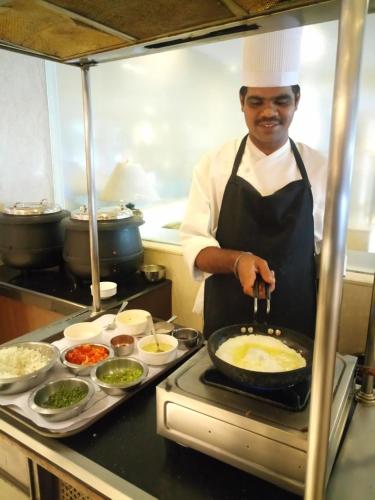 a chef is preparing food in a kitchen at Hampshire Plaza in Hyderabad