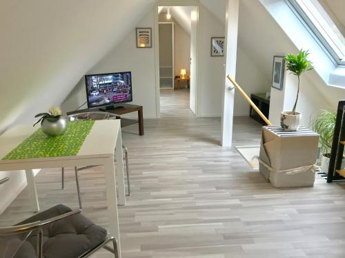 a room with a staircase with a table and a television at Gästehaus Kaiser in Ostfildern
