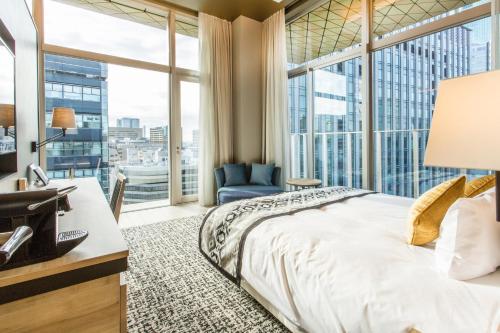 فندق ميوزيه غينزا ميتتسه في طوكيو: غرفة نوم بسرير ونافذة كبيرة