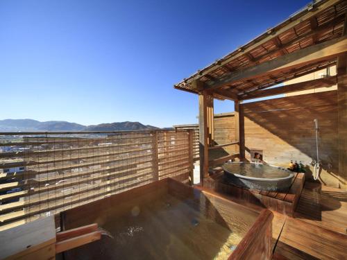 a bath tub on the deck of a house at Hotel Tsubakino in Yamanouchi
