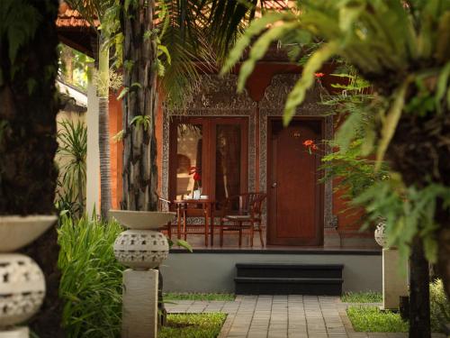a front porch of a house with a table and chairs at Griya Santrian a Beach Resort And Spa in Sanur