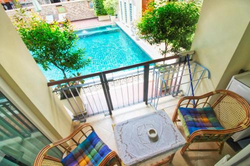 a balcony with two chairs and a swimming pool at The Paradise Jomtien Beach in Jomtien Beach