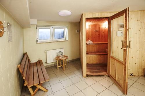 une chambre avec une porte, un banc et une table dans l'établissement Hotel Dukat, à Biała Podlaska