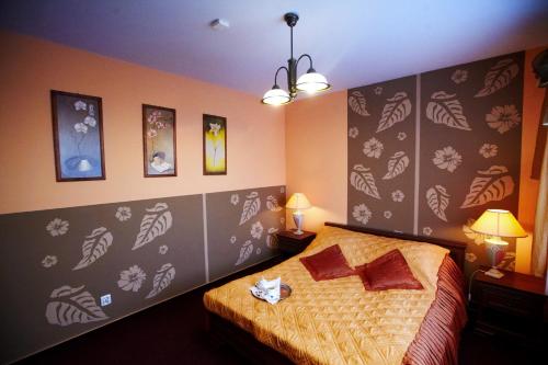 a bedroom with a bed with leaves on the wall at Hotel Dukat in Biała Podlaska