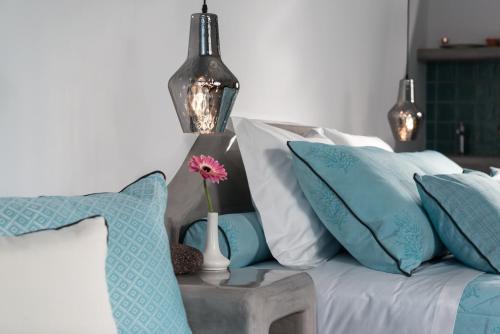 a couch with pillows and a vase with a flower on a table at Elements of Caldera Suites in Akrotiri