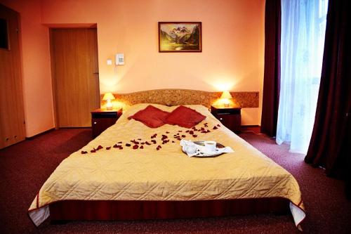 a hotel room with a bed with flowers on it at Hotel Dukat in Biała Podlaska