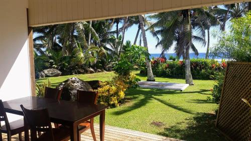a patio with a table and a view of the ocean at Herons Reef Holiday Apartments in Rarotonga