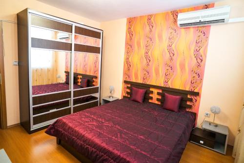 1 dormitorio con cama roja y espejo grande en Apartment Geo Milev, en Plovdiv