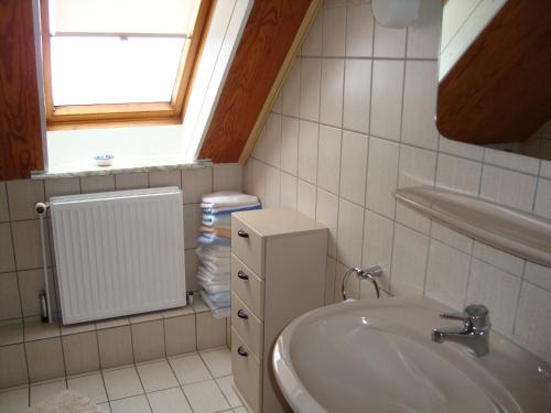 een badkamer met een wastafel en een raam bij Ferienwohnung Stauch in Tating