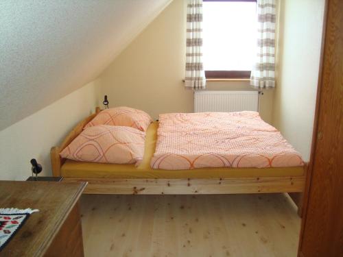 een slaapkamer met een bed en een raam bij Ferienwohnung Stauch in Tating