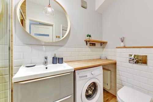 a bathroom with a washing machine and a mirror at Motława Apartment - the Best Location in Gdańsk
