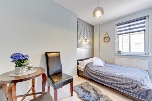 グダニスクにあるMotława Apartment - the Best Locationのベッドルーム1室(ベッド1台、テーブル、椅子付)