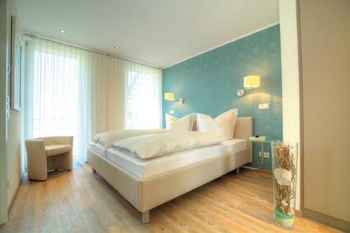 a bedroom with a bed and a blue wall at Penthouse Müritzblick in Rechlin