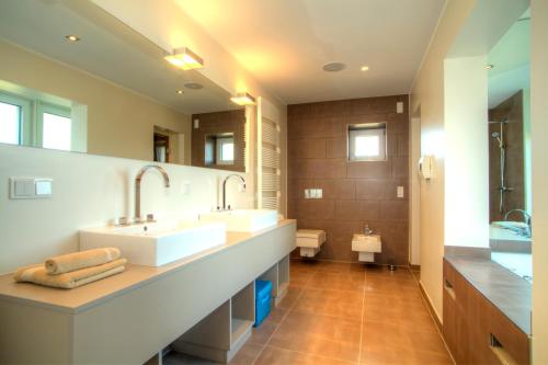 a bathroom with two sinks and a large mirror at Penthouse Müritzblick in Rechlin