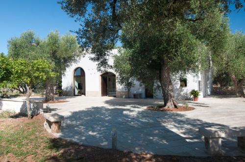 um edifício com uma árvore no meio de um pátio em Agriturismo Villa Coluccia em Martano