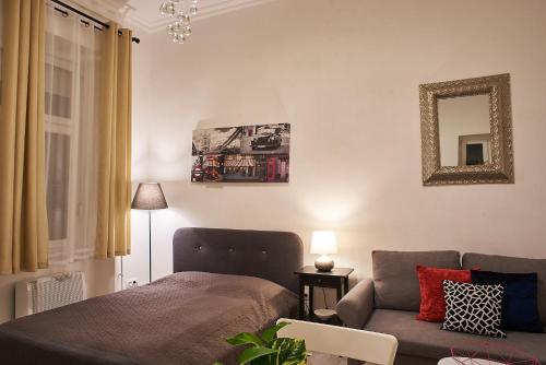 una sala de estar con una cama y un sofá en CLAUDIA Apartments Budapest, en Budapest