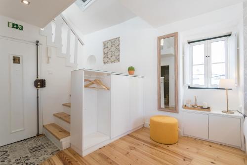 リスボンにあるAlfama Loft Studio Loft Apartment w/ River View - by LU Holidaysの白い壁と黄色の椅子が備わる部屋