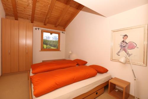 ポントレジーナにあるChesa Striun Eidenbenzのベッドルーム1室(オレンジ色のベッド1台、窓付)