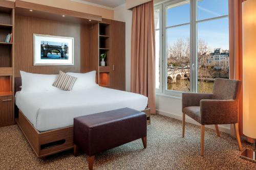  سيتدينس سان جيرمان دي بري في باريس في باريس: غرفة نوم بسرير وكرسي ونافذة